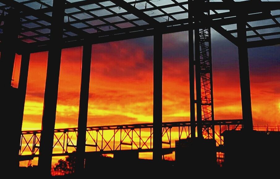 SILHOUETTE BUILT STRUCTURES AGAINST ORANGE SKY