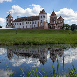 Houses by lake against sky