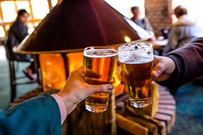 Midsection of woman holding beer glass