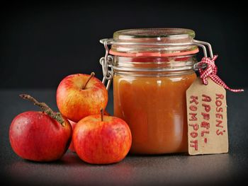 Close-up of apples in glass jar on table