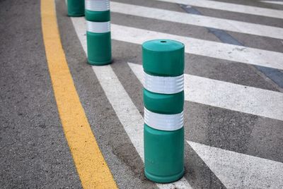 High angle view of green and white bollards on road