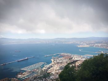 High angle view of city by sea against sky