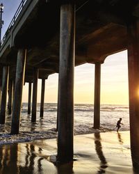 Pier over sea against sky during sunset