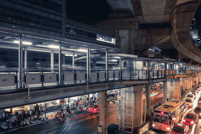 Vehicles on road under bridge at night