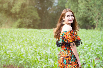 Portrait of young woman standing in field