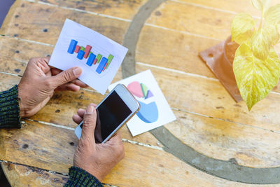 Cropped image of woman holding graph at table