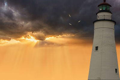 Low angle view of lighthouse against sky during sunset