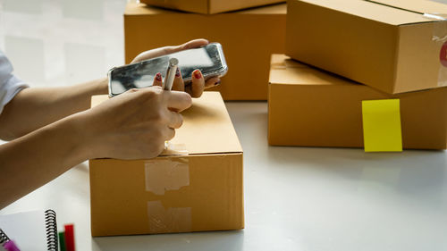 Midsection of person holding paper in box