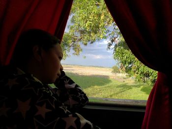 Portrait of boy looking through window