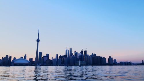 City at waterfront against clear sky