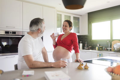 Rear view of woman holding ice cream in kitchen