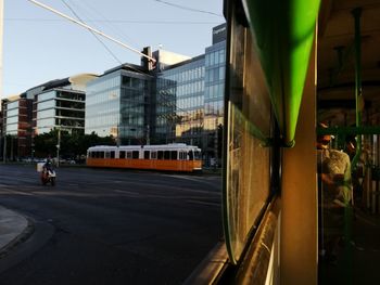 Cars on road in city against sky