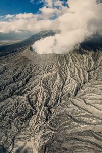 Scenic view of volcanic landscape against cloudy sky