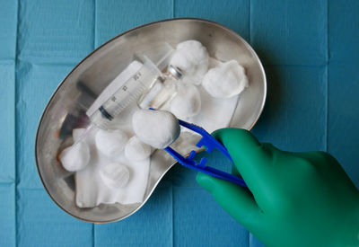 Close-up of surgeon holding clamp above medical tray