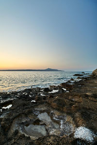 Scenic view of sea against clear sky during sunset