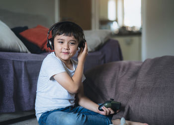 Portrait of boy sitting on sofa at home