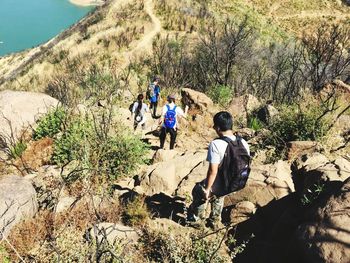 Rear view of people walking on rock