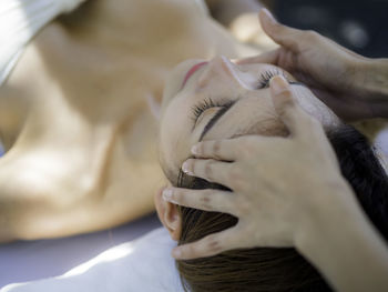 Cropped hands of therapist massaging woman at spa