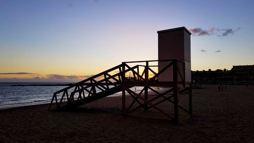 Scenic view of lifeguard hut against sky during sunset