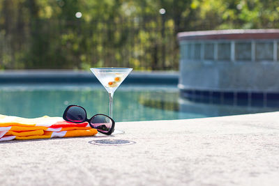 Sunglasses and drink with fabric at poolside