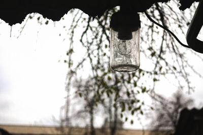 Low angle view of illuminated lamp hanging against sky