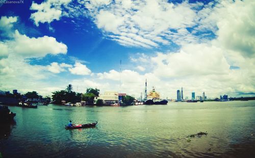 Boats in river with city in background