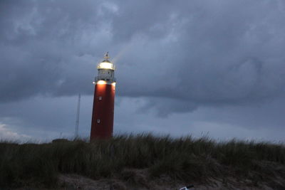 Lighthouse against cloudy sky at dusk