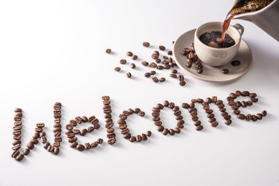 High angle view of coffee beans against white background