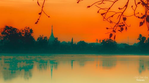 Scenic view of lake against orange sky