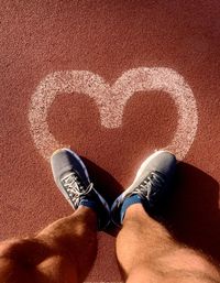 Low section of man standing on heart shape