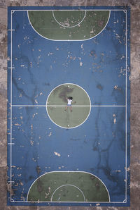 Aerial view of man lying on basketball court
