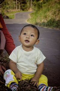 Portrait of cute boy sitting outdoors