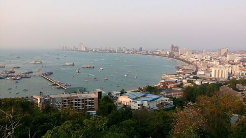 High angle view of cityscape by sea against clear sky