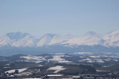 Aerial view of snowcapped mountains against clear sky