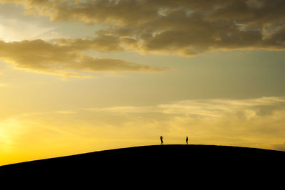 Scenic view of silhouette hill against sky during sunset