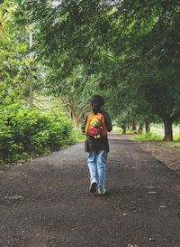 Rear view of woman walking on road
