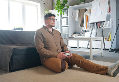 Young man sitting on sofa at home