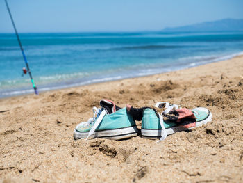 Lounge chairs on sand at beach against blue sky