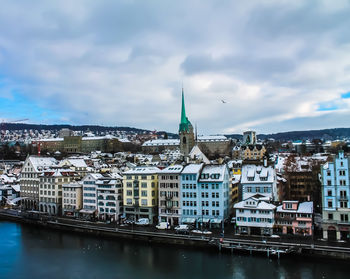 River amidst buildings in city against sky