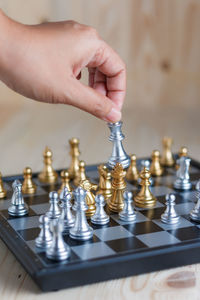 Cropped hand playing chess on table