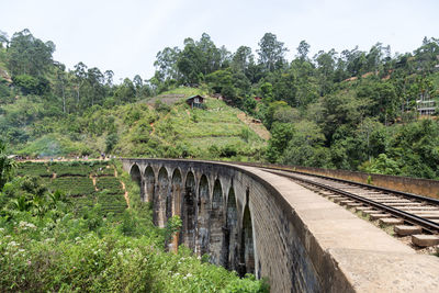 Railroad tracks by bridge against sky