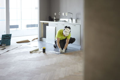 Worker installing floor in kitchen