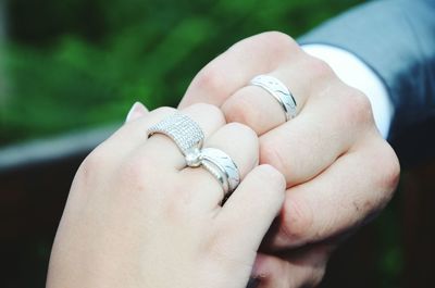 Cropped hands of couple showing engagement rings