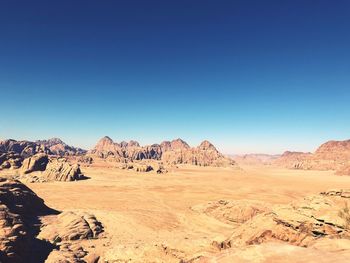 Scenic view of desert against clear blue sky