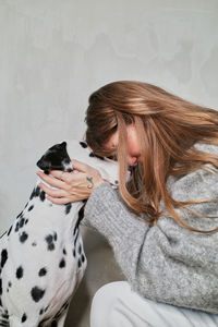 Side view of woman with dog on floor at home