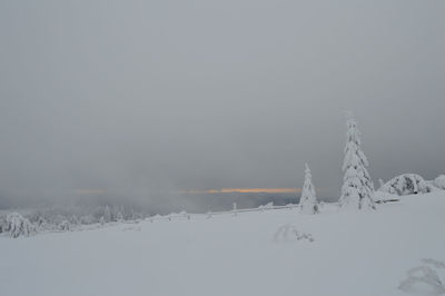 Snow covered landscape against clear sky