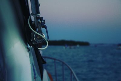 Close-up of boat sailing on sea against sky