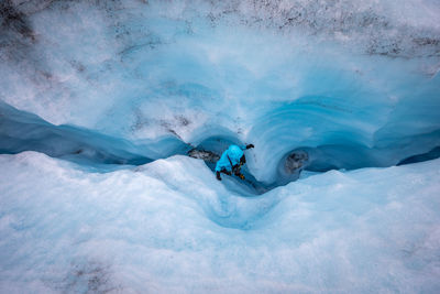 High angle view of person walking amidst glacier