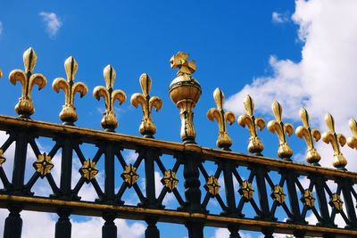 Low angle view of iron fence against sky at buckingham palace