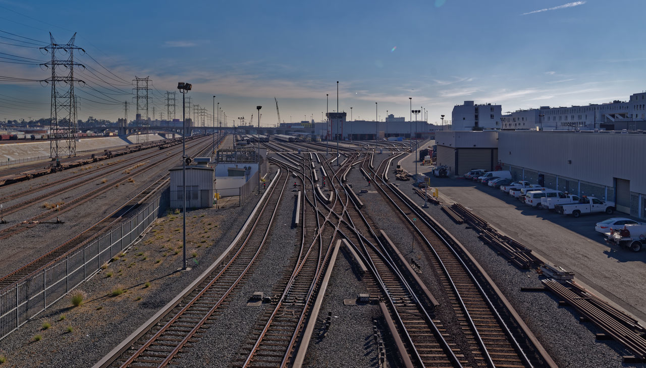 railroad track, transportation, rail transportation, high angle view, public transportation, sky, mode of transport, railway track, outdoors, no people, day, train - vehicle, cable, railroad station, complexity, nature, electricity pylon